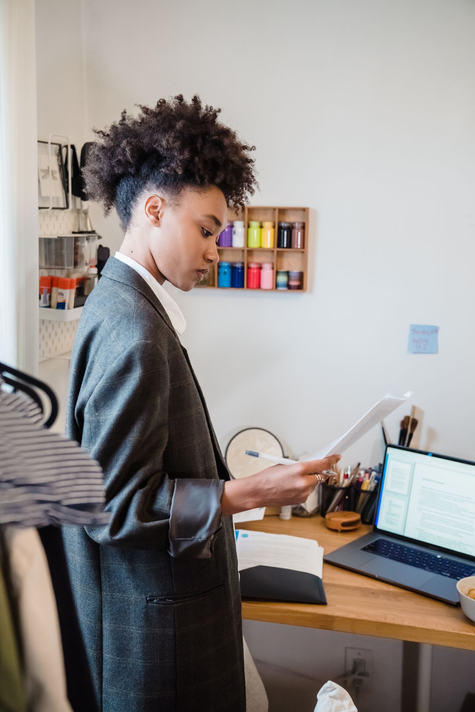 A professional reviewing printed terms beside a laptop