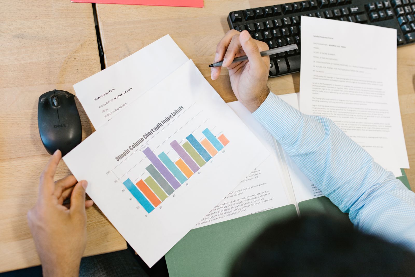 An editor reviewing a printed chart and report at a desk