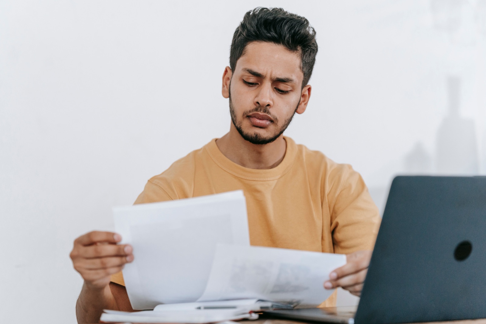 An editor comparing printed documents beside a laptop